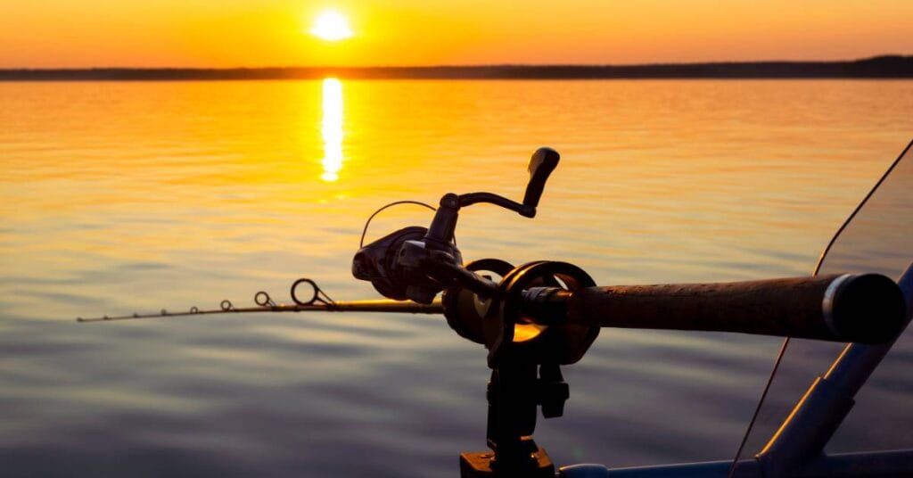 wedki spinningowe widok na wodzie z zachodem slonca